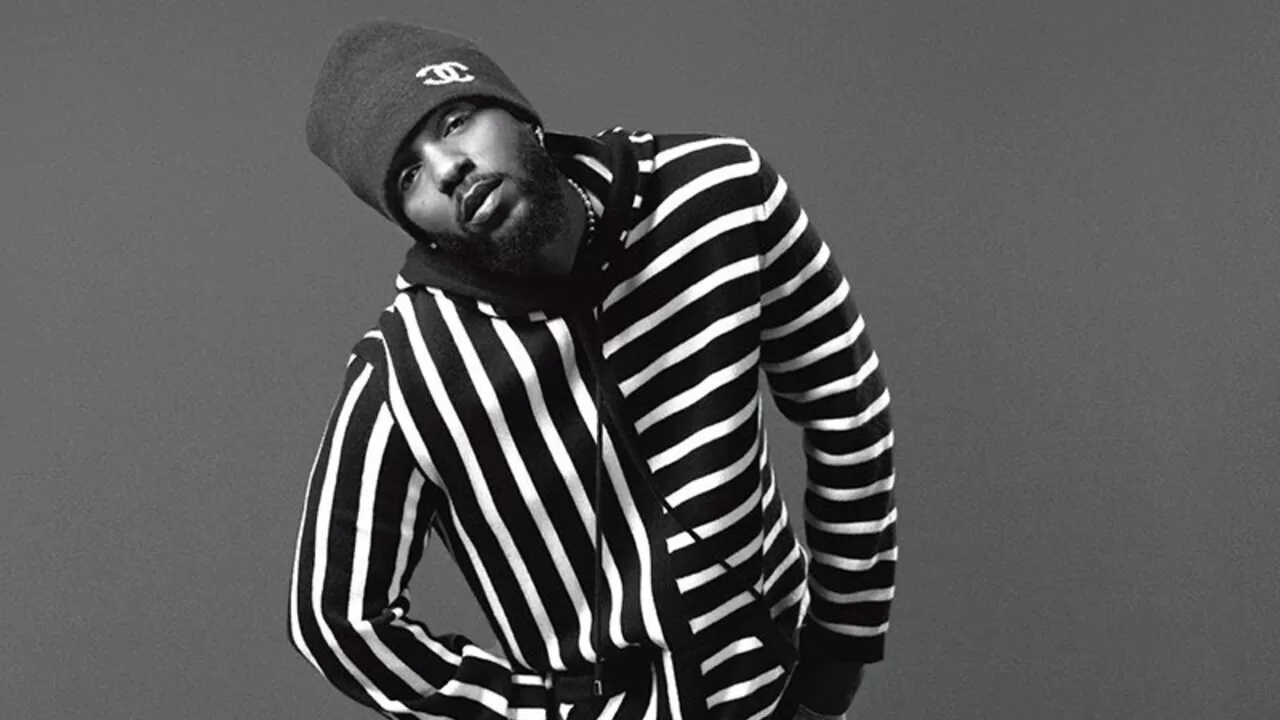 Cantor americano Kendrick Lamar vestindo um casaco listrado horizontalmente e touca