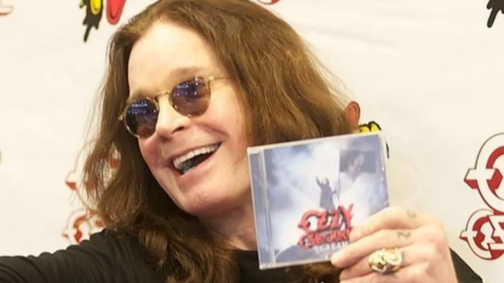 Ozzy Osbourne sorrindo e segurando seu disco "Scream".